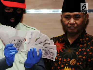 Pimpinan KPK, Agus Rahardjo (kanan) bersama Penyidik menunjukan barang bukti Oprasi Tangkap Tangan (OTT) uang 130.000 Dollar Singapore atau setara Rp 1,3 milyar di gedung KPK, Jakarta, Rabu (29/8). (merdeka.com/Dwi Narwoko)