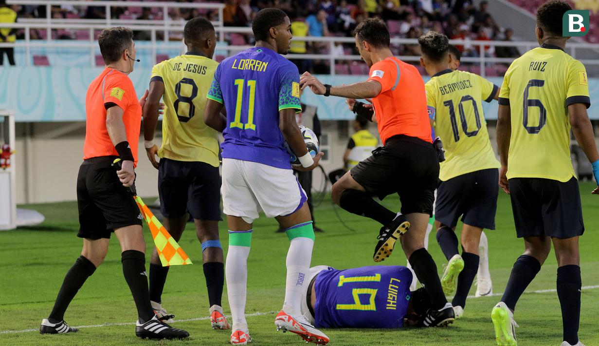 <p>Wasit asal Turki, Atilla Karaoglan (tengah) dan asisten wasit Ceyhun Sesiguzel, berusaha melerai keributan yang terjadi antara para pemain Timnas Brasil U-17 dengan para pemain Ekuador U-17 dalam pertandingan babak 16 Besar Piala Dunia U-17 di Stadion Manahan, Solo, Senin (20/11/2023). (Bola.com/Arief Bagus)</p>