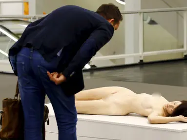 Seorang pria saat melihat patung karya John de Andrea yang bernama " Lisa " selama Art Cologne 2016 di Jerman 15 April 2016. Patung yang sangat menyerupai manusia ini terbuat dari perunggu, minyak olychromed dan rambut asli. (REUTERS / Wolfgang Rattay)