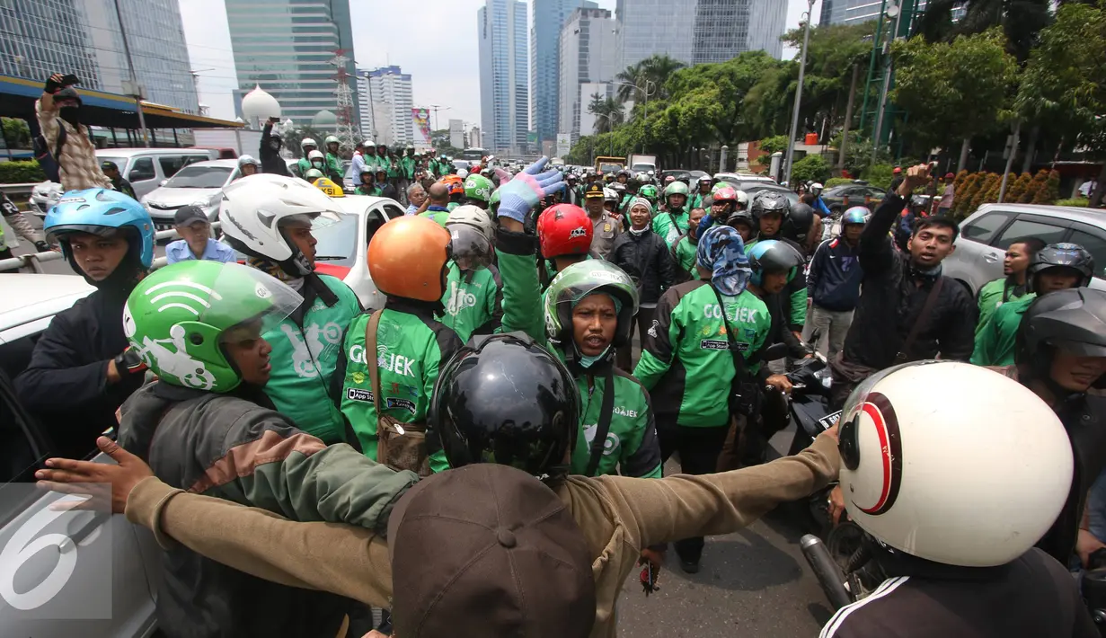 Ratusan pengendara Go-Jek terlibat kericuhan dengan sopir taksi di Jakarta, Selasa (22/3). Ratusan Go-Jek mendatangi para sopir taksi karena tersebar isu pemukulan terhadap beberapa pengendara Go-Jek oleh sopir taksi.  (Liputan6.com/Immanuel Antonius)