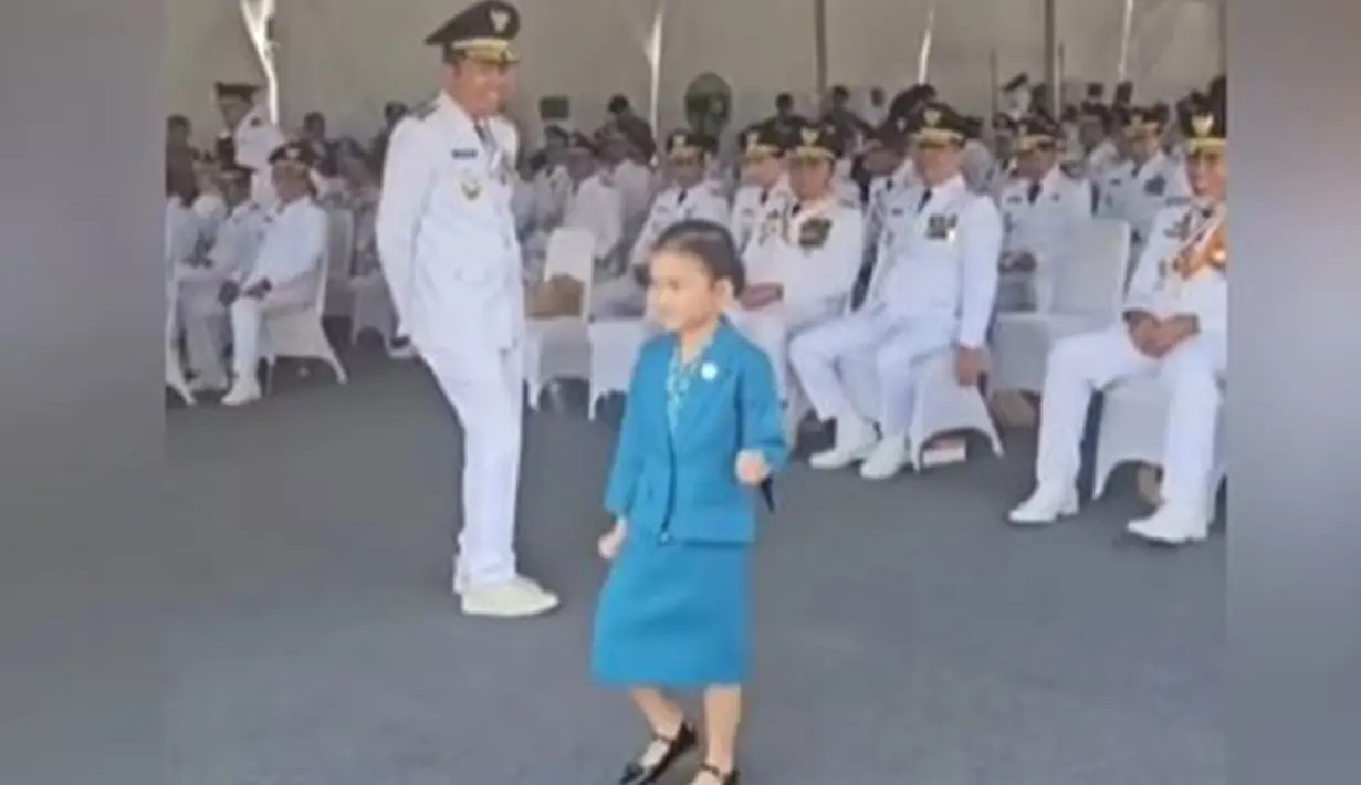 Dalam momen bersejarah ini, Dedi ditemani putri bungsunya, Hyang Sukma Ayu, yang mencuri perhatian saat berdiri di antara kepala daerah. Gadis kecil itu tampak antusias mengikuti prosesi, menirukan gerakan baris-berbaris dengan ceria. (Liputan6.com/IG/@dedimulyadi71)