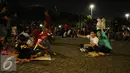 Pengunjung duduk duduk di halaman Monumen Nasional, Jakarta, Sabtu (31/12). Dengan alasan keamanan, Pemprov DKI Jakarta membatalkan panggung hiburan malam pergantian tahun di kawasan Monumen Nasional. (Liputan6.com/Helmi Fithriansyah)