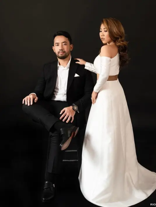 Kiky Saputri tampil elegan dalam balutan one shoulder crop top berwarna putih dan rok panjang warna senada dari Etiquette White Bride.