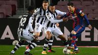 Striker Barcelona, Lionel Messi, berusaha melewati pemain Levante pada laga Liga Spanyol di Stadion Camp Nou, Senin (14/12/2020). Barcelona menang dengan skor 1-0. (AFP/Lluis Gene)