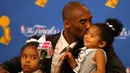Pebasket LA Lakers, Kobe Bryant, mencium putrinya Gianna usai mengalahkan Boston Celtics pada laga NBA di Staples Center, Los Angeles, Sabtu (15/6/2008). (AFP/Jed Jacobsohn)