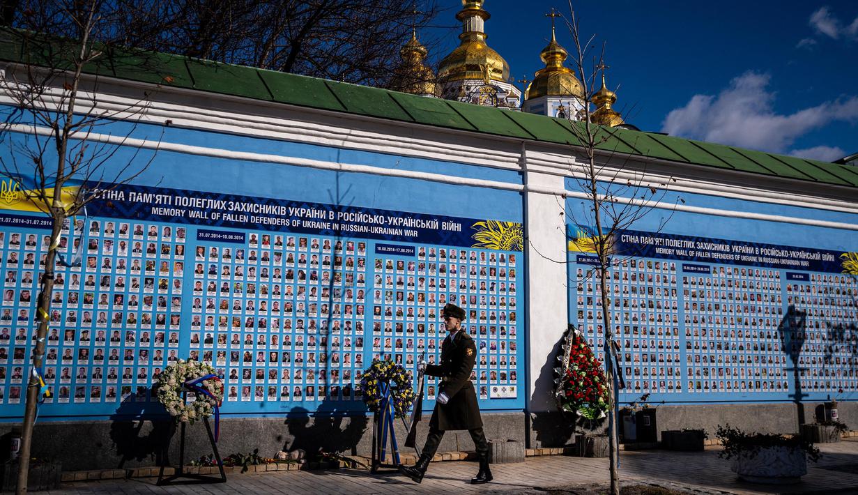 Pasukan kehormatan Ukraina berdiri di depan Tugu Peringatan bagi mereka yang Gugur untuk Ukraina di Kyiv pada tanggal 20 Februari 2023. Presiden AS Joe Biden menjanjikan peningkatan pengiriman senjata untuk Ukraina selama kunjungan mendadak ke Kyiv pada 20 Februari 2023, di mana ia juga menjanjikan komitmen Washington dalam membela integritas teritorial Ukraina. (Dimitar DILKOFF/AFP)
