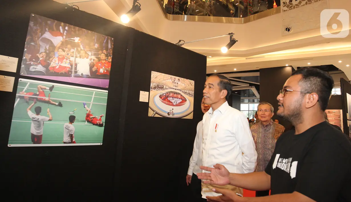 Presiden Joko Widodo atau Jokowi memerhatikan foto-foto yang ditampilkan dalam pameran foto 'Membangun Indonesia'  di Jakarta, Selasa (12/11/2019). Pameran foto itu menampilkan sejumlah capaian kinerja pemerintahan Presiden Joko-Widodo dan Wakil Presiden Jusuf Kalla. (Liputan6.com/Angga Yuniar)