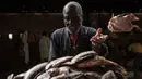 Pedagang melempar ikan setelah membersikan sisiknya di sebuah pasar ikan di dekat Sungai Nil, di kota kembar Khartoum, Omdurman (24/6/2019). Omdurman merupakan kota terbesar di Sudan memiliki jumlah penduduk sebanyak 1,2 juta jiwa (1993). (AFP Photo/Yasuyoshi Chiba)
