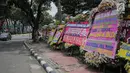 Sejumlah karangan bunga bertuliskan ucapan selamat untuk Joko Widodo (Jokowi) dan Ma'ruf Amin di depan pagar gedung Sekretariat Negara, Jakarta, Senin (22/4). Karangan bunga dari pendukung Jokowi-Ma'ruf tersebut ditujukan atas kemenangan pasangan itu pada Pilpres 2019. (Liputan6.com/Faizal Fanani)
