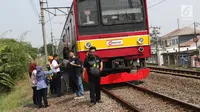 Sejumlah penumpang KRL Commuter Line terpaksa berjalan kaki menuju Stasiun Bojonggede, Bogor, Jawa Barat, Minggu (4/8/2019). Padamnya listrik di wilayah Jabodetabek mengakibatkan perjalanan KRL Commuter Line terhenti. (Liputan6.com/Helmi Fithriansyah)