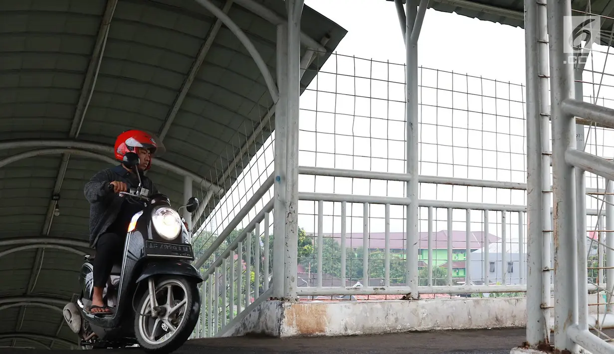Pemotor melintasi jembatan penyeberangan orang (JPO) di kawasan Pasar Minggu, Jakarta, Rabu (24/4). Kurangnya kesadaran akan tertib berlalu lintas menyebabkan para pemotor itu nekat melintasi JPO, meskipun dapat merugikan hak pejalan kaki. (Liputan6.com/Immanuel Antonius)