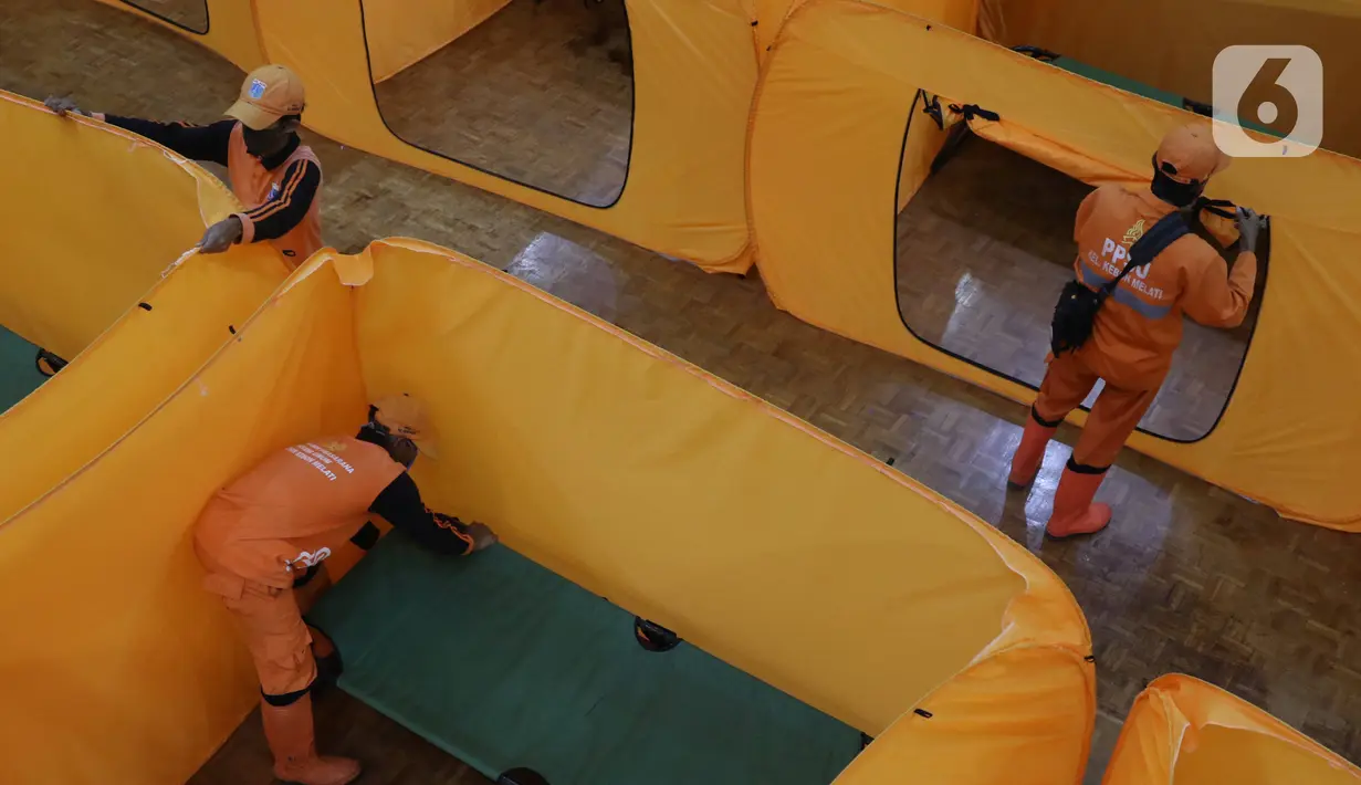 Petugas merapihkan tenda yang akan dijadikan tempat isolasi Covid-19 di gedung kesenian Tanah Abang, Jakarta, Minggu (17/5/2020). Gedung ini dijadikan tempat isolasi bagi masyarakat yang  akan mengikuti rapid test esok dilokasi tersebut. (Liputan6.com/Angga Yuniar)