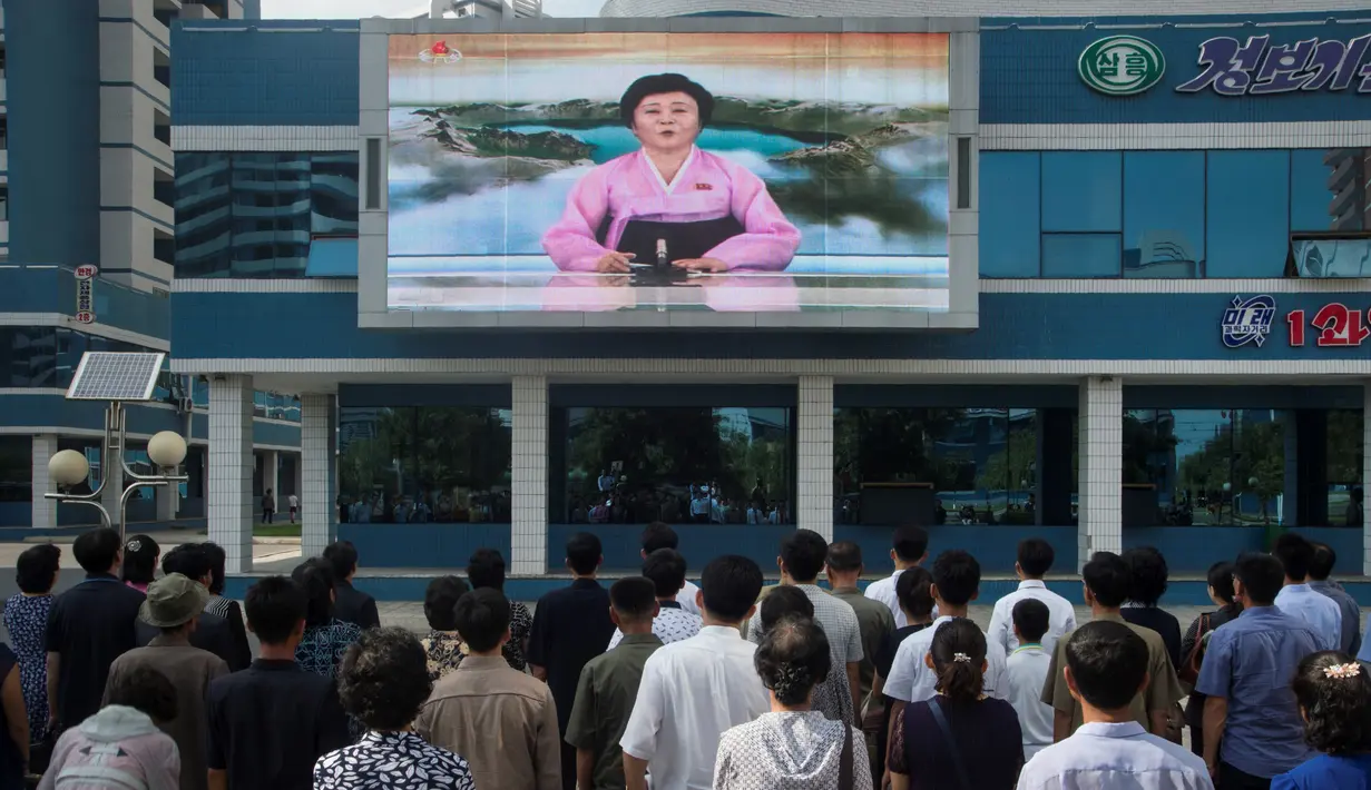  Warga menonton sebuah layar video besar di Mirae Scientists Street di Pyongyang yang menampilkan pembaca berita Ri Chun-Hee saat dia mengumumkan bahwa negara tersebut telah berhasil menguji sebuah bom hidrogen pada Senin (3/9). (AFP Photo/Kim Won-Jin)