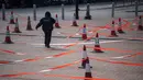 Seorang wanita berjalan ke tempat pengujian virus corona COVID-19 di Hong Kong, 12 Februari 2022. Pihak berwenang bergegas untuk meningkatkan kapasitas pengujian COVID-19 menyusul rekor tertinggi infeksi baru. (Louise Delmotte/AFP)