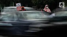 Masyarakat membawa poster dan bendera Palestina di jalan Basuki Rahmat, Jakarta, Kamis (20/5/2020). Aksi masyarakat tersebut untuk mengutuk penyerangan Israel ke Palestina yang telah menyebabkan ratusan korban jiwa. (Liputan6.com/Johan Tallo)