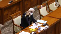 Calon Hakim Agung Tata Usaha Negara (TUN) khusus pajak Triyono Martanto melambaikan tangan saat uji kelayakan di ruang rapat Komisi III DPR, kompleks Parlemen, Jakarta, Rabu (27/1/2021). Komisi III menghentikan uji kelayakan terhadap Triyono karena diduga plagiat. (Liputan6.com/Angga Yuniar)