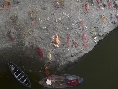 Kuburan dangkal di pasir, beberapa di antaranya diduga orang yang meninggal karena virus corona COVID-19, terlihat dekat tempat kremasi di tepi Sungai Gangga, Phafamau, Allahabad, India, Sabtu (5/6/2021). (SANJAY KANOJIA/AFP)