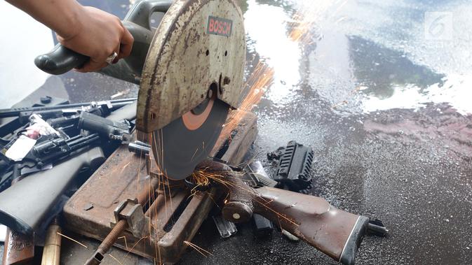 Senjata api dimusnahkan menggunakan mesin pemotong besi di Kejaksaan Negeri Jakarta Timur, Rabu (24/4). Barang bukti yang dimusnahkan berupa senjata api, senjata tajam dan beberapa jenis narkoba hasil pengungkapan kasus hukum di wilayah Jakarta Timur periode 2018-2019. (merdeka.com/Imam Buhori)