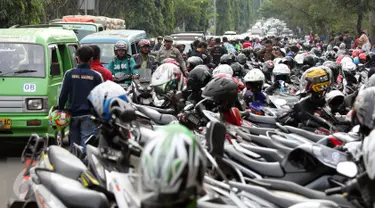 Pengendara antre melintasi Jalan Tegar Beriman Kab Bogor, Selasa (13/12). Ribuan calon suporter Timnas Indonesia antre membeli tiket laga final pertama di halaman Kodim 0621 Surya Kancana. (Liputan6.com/Helmi Fithriansyah)