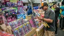 Seorang pedagang menata kembang api di Pasar Asemka, Jakarta, Selasa (29/12/2020). Sejumlah pedagang menyatakan, jelang perayaan Tahun Baru 2021 ini penjualan kembang api mengalami penurunan 75 persen dari tahun lalu. (Liputan6.com/Faizal Fanani)