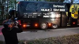 Awak media mengambil gambar kondisi bus tim Borussia Dortmund yang rusak terkena ledakan bom di Dortmund, Jerman Barat, Selasa (11/4). Dalam insiden itu, Bek Dortmund Marc Bartra mengalami luka di tangan terkena pecahan kaca. (AP Photo/Martin Meissner)