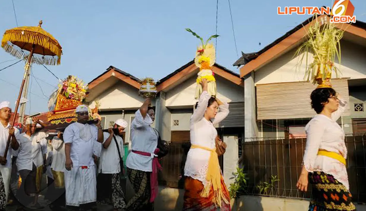  Dengan berpakaian adat khas Bali, tampak rombongan yang membawa sesaji untuk Upacara Melasti (Liputan6.com/Andrian M Tunay)
