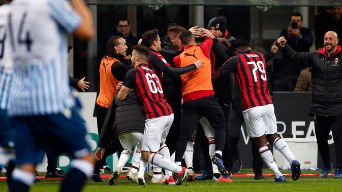 Para pemain AC Milan memeluk Gonzalo Higuain setelah mencetak gol selama pertandingan melawan SPAL pada lanjutan Liga Serie A Italia di stadion San Siro (29/12). Milan menang tipis atas SPAL 2-1. (AP Photo/Antonio Calanni)