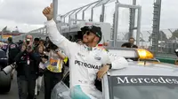 Pembalap Mercedes F1 Lewis Hamilton memberikan acungan jempol setelah kualifikasi di Australian Formula One Grand Prix di Melbourne (19/3). Posisi kedua ditempati rekan setim Hamilton, yakni Nico Rosberg. (REUTERS/Brandon Malone)