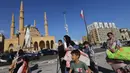 Orang-orang yang melarikan diri dari pengeboman Israel di pinggiran selatan Beirut, berkumpul dengan barang-barang mereka di Martyrs Square di pusat ibu kota Lebanon di mana mereka bermalam pada 28 September 2024. (JOSEPH EID/AFP)
