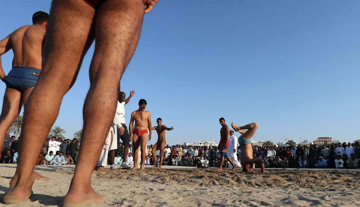 Seorang pegulat beraksi menghibur penonton dalam kompetisi gulat Greco-Roman mingguan di Dubai (16/3). Dalam gulat Greco-Roman, pegulat hanya menggunakan tangan dan badan bagian atas untuk menyerang. (AFP Photo/Karim Sahib)