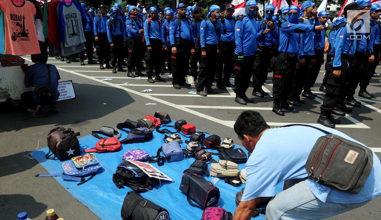 Pedagang kaki lima menjajakan barang dagangan saat Demo Hari Buruh di Jakarta, Selasa (1/5). Pedagang kaki lima ini memanfaatkan Hari Buruh untuk mengais rejeki dengan berjualan saat demontrasi berlangsung. (Liputan6.com/Johan Tallo)