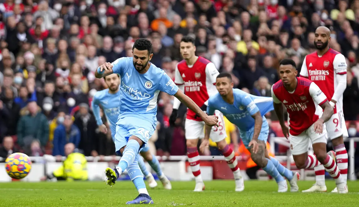 Pemain Manchester City Riyad Mahrez melakukan tendangan penalti ke gawang Arsenal pada pertandingan sepak bola Liga Inggris di Stadion Emirates, London, Inggris, 1 Januari 2022. Manchester City menang 2-1. (AP Photo/Matt Dunham)