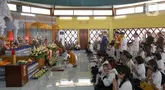 Umat Buddha mengikuti prosesi Puja Bakti di Wihara Arya Dwipa Arama, Taman Mini Indonesia Indah (TMII), Jakarta, Senin (12/5/2025). (Liputan6.com/Herman Zakharia)