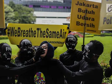 Aktivis Greenpeace melakukan aksi teatrikal di Kementerian Lingkungan Hidup, Selasa (5/3). Greenpeace mencatat konsentransi PM 2.5 atau di Jakarta mencapai empat kali lipat di atas batas aman tahunan menurut standar WHO. (Liputan6.com/Faizal Fanani)