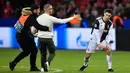 Seorang penyusup dievakuasi saat masuk ke lapangan untuk memeluk Cristiano Ronaldo pada laga Liga Champions antara Juventus melawan Bayer Leverkusen di Bay Arena, Leverkusen, Jerman, Rabu (11/12/2019). (AP Photo/Martin Meissner)