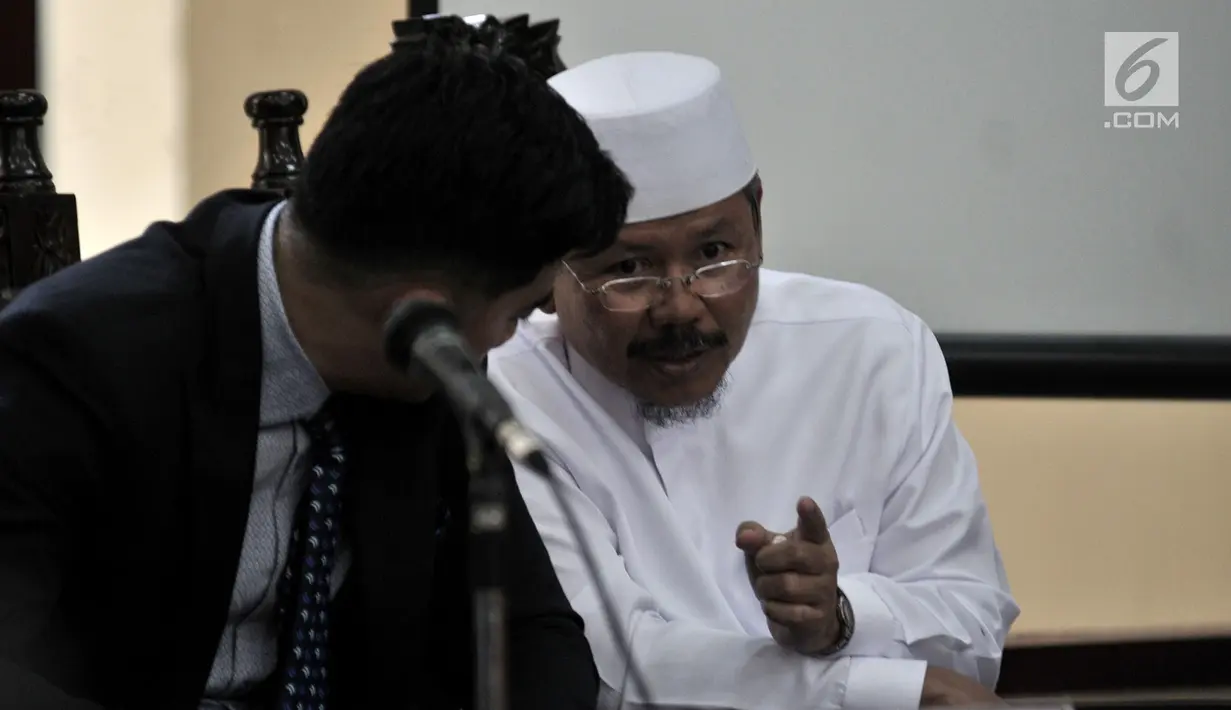 Juru Bicara HTI Ismail Yusanto (kanan) berbincang dengan kuasa hukumnya saat sidang putusan di PTUN Jakarta, Senin (7/5). Majelis hakim menolak gugatan yang diajukan HTI. (Merdeka.com/Iqbal Nugroho)