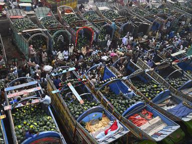 Orang-orang berdagang semangka di pasar buah di Lahore, Pakistan (12/4/2022).  Semangka biasa dipanen buahnya untuk dimakan segar atau dibuat jus. (AFP/Arif Ali)