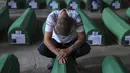 <p>Seorang pria muslim berduka di samping peti mati kerabatnya, korban genosida Srebrenica 1995, di Potocari, Bosnia, Minggu (9/7/2023). Sebanyak 30 jenazah korban pembantaian Srebrenica yang baru diidentifikasi, satu-satunya genosida yang diakui di Eropa sejak Perang Dunia II, tiba di Pusat Peringatan di Potocari dimana mereka akan dimakamkan pada 11 Juli. (AP Photo/Armin Durgut)</p>
