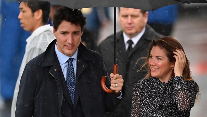 File foto 27 Juni 2019, PM Kanada Justin Trudeau dan istrinya Sophie Gregorie Trudeau tiba jelang KTT G20 Osaka di bandara Kansai. Istri PM Kanada dinyatakan positif Virus Corona COVID-19 pada Kamis 12 Maret setelah mulai merasa sakit pada Rabu malam sekembalinya dari London. (CHARLY TRIBALLEAU/AFP)