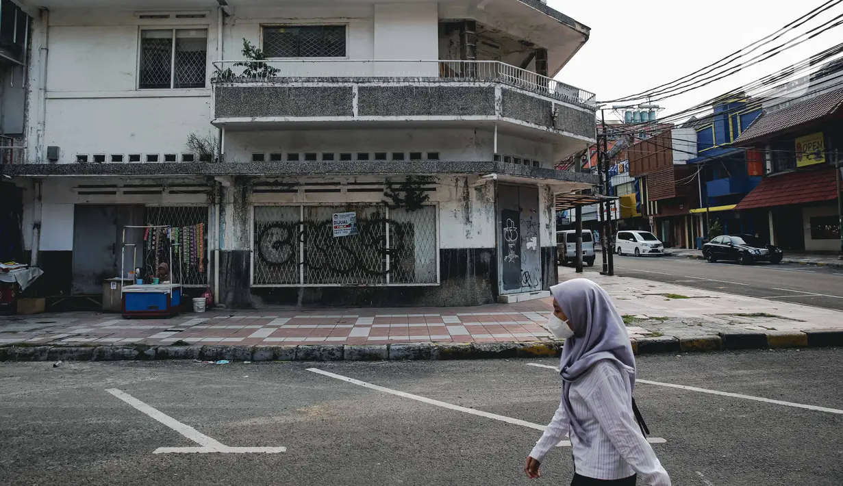 Warga berjalan di dekat pertokoan yang tutup di kawasan little Tokyo, Blok M, Jakarta, Rabu (21/7/2021). Pemerintah resmi menetapkan pemberlakuan pembatasan kegiatan masyarakat (PPKM) level 4 hingga 25 Juli mendatang untuk mencegah penyebaran virus Covid-19. (Liputan6.comn/Faizal Fanani)