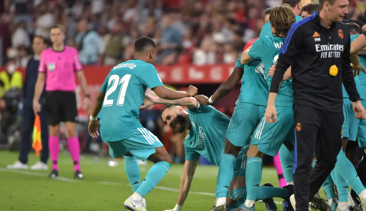 Sontak seluruh pemain dan juga ofisial tim langsung menghampirinya untuk merayakan epic comeback yang diraih Real Madrid saat bertamu ke kandang Sevilla. (AFP/Cristina Quicler)