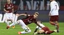 Gelandang AS Roma, Radja Nainggolan, jatuh saat berebut bola dengan gelandang AC Milan, Lucas Biglia, pada laga Serie A Italia di Stadion San Siro, Milan, Minggu (1/10/2017). Milan kalah 0-2 dari Roma. (AFP/Miguel Medina)