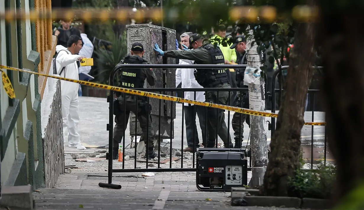 Polisi penjinak bom melakukan pemeriksaan di lokasi ledakan di dekat arena adu banteng Plaza Santamaria di pusat kota Bogota, Kolombia, Minggu (19/2). Peristiwa itu menyebabkan satu orang polisi tewas dan sebanyak 30 orang terluka. (STR/AFP)