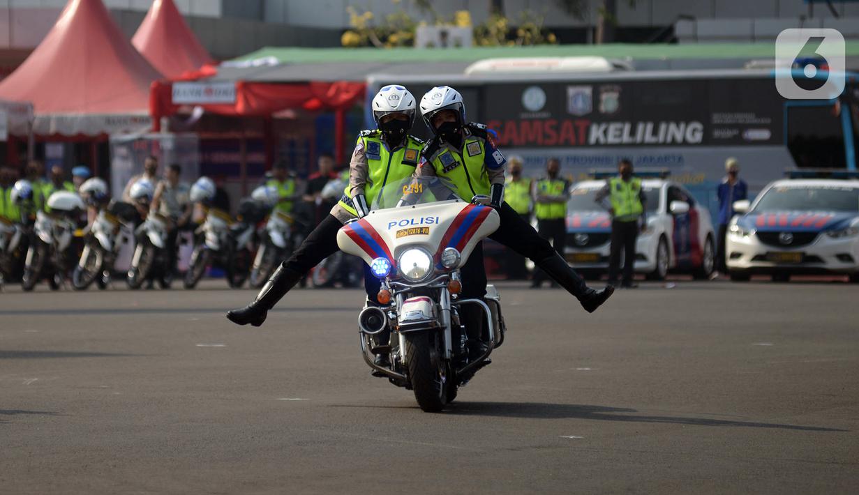 Polisi melakukan atraksi mengendarai motor gede saat apel pasukan Operasi Patuh Jaya 2020 di Lapangan Polda Metro Jaya, Jakarta, Kamis (23/7/2020). Sebanyak 1.800 personel gabungan TNI-Polri diturunkan dalam Operasi Patuh Jaya 2020. (merdeka.com/Imam Buhori)