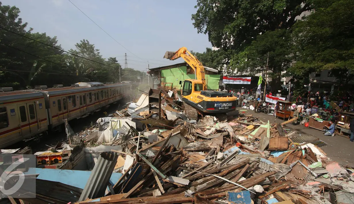 Alat berat merobohkan bangunan di kawasam Rawajati, Jakarta, Kamis (1/9). Penertiban puluhan bangunan liar di kawasan tersebut menyebabkan warga terpaksa menyelamatkan barang berharga mereka ke tepi rel kereta api. (Liputan6.com/Immanuel Antonius)