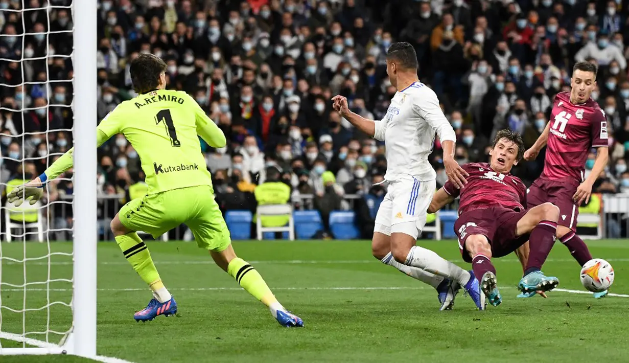 Pemain Real Madrid Casemiro (tengah) berebut bola dengan pemain Real Sociedad Robin Le Normand (kedua kanan) pada pertandingan sepak bola Liga Spanyol di Stadion Santiago Bernabeu, Madrid, Spanyol, 5 Maret 2022. Real Madrid menang 4-1. (PIERRE-PHILIPPE MARCOU/AFP)