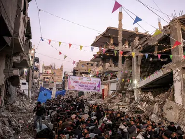 Orang-orang berkumpul untuk berbuka puasa pada hari pertama bulan puasa Ramadan di Jabalia, Jalur Gaza utara, pada 1 Maret 2025. (Bashar TALEB/AFP)