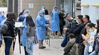 Orang-orang mengantre untuk tes COVID-19 di Distrik Yuen Long, Hong Kong, Selasa (15/2/2022). Hong Kong menghadapi gelombang virus corona COVID-19 terburuk hingga saat ini. (Peter PARKS/AFP)