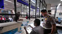 Petugas memberi penjelasan pada wajib pajak di Samsat Jakarta Pusat, Kamis (11/12/2014). (Liputan6.com/Johan Tallo)