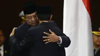 Presiden RI ke-6, Susilo Bambang Yudhoyono (SBY) merangkul presiden terpilih 2014, Joko Widodo (Jokowi) setelah upacara pengambilan sumpah di House of Representative di Jakarta pada 20 Oktober 2014. (AFP PHOTO / ROMEO GACAD)